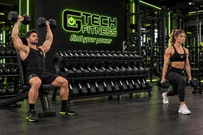 Athletes Exercising with a Dumbbell Set and Rack in a Commercial Gym