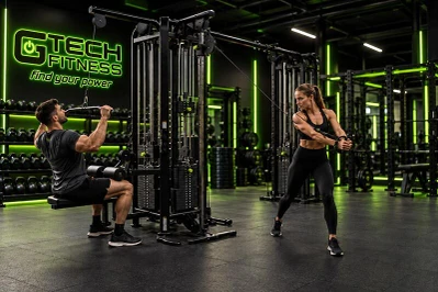 People Exercising with Gym Cable Attachments in Commercial Fitness Center